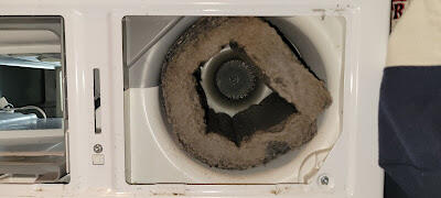 Vision Appliance Professionals A dirty washing machine with a visible hole in the door, indicating potential damage or malfunction.